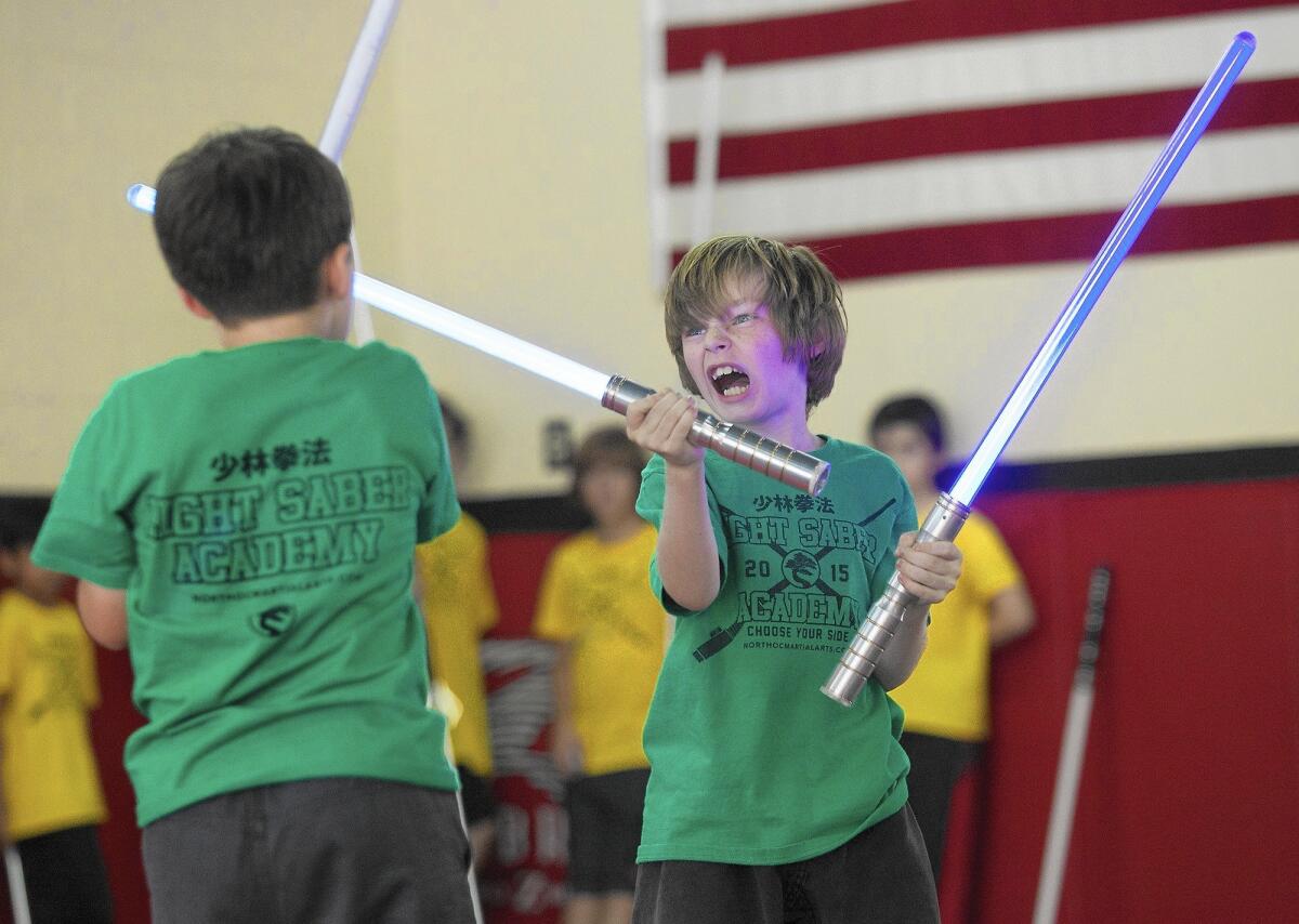 Evan Neylan, right, and Jack Hubbard, rehearse a fight routine during the last day of camp before a final showcase for family and friends at United Studios of Self Defense (USSD) in Yorba Linda on July 24. Twenty-one children, ages 5-13, took part in USSD's five-day Light Saber Academy.