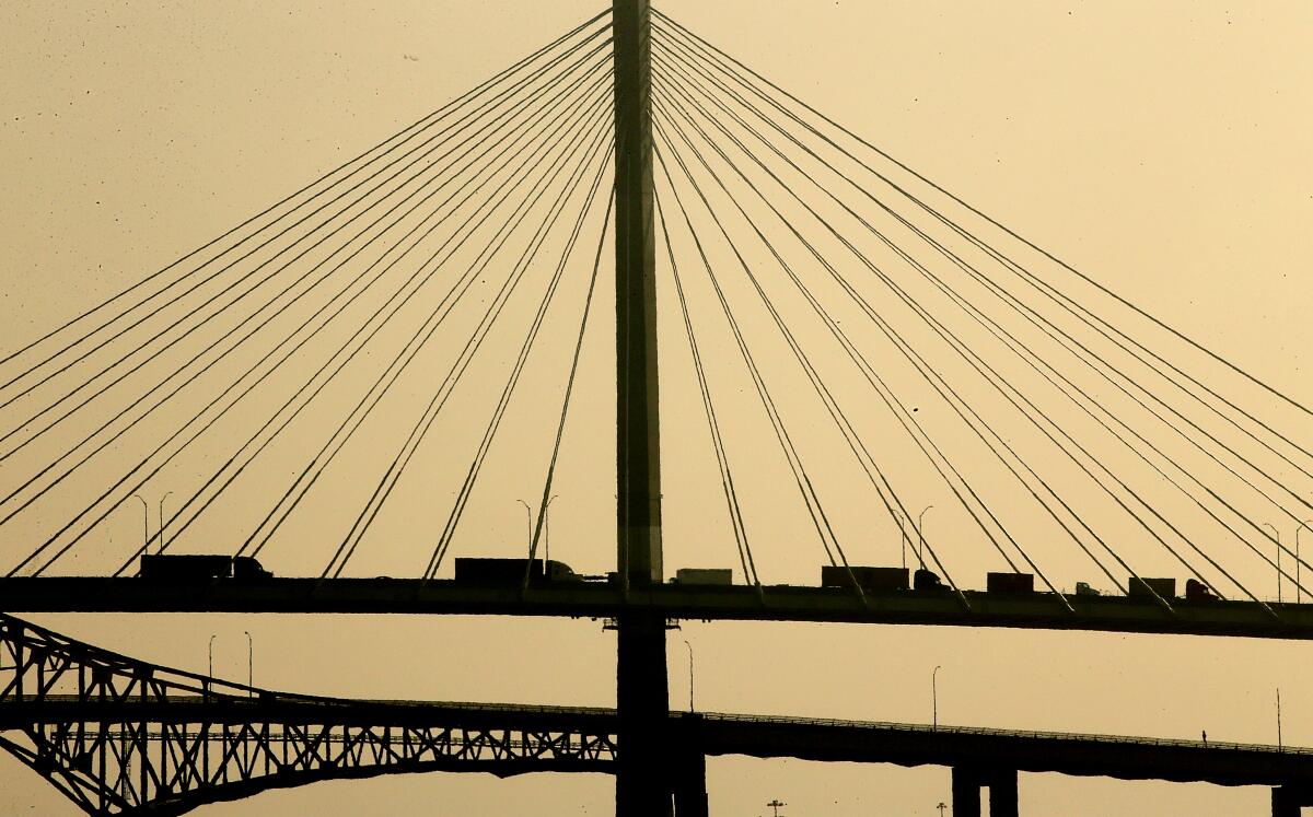 Trucks haul cargo containers across the Gerald Desmond Bridge at the Port of Long Beach.