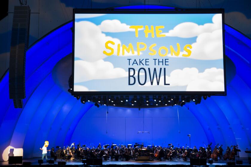 Thomas Wilkins, conductor of the Hollywood Bowl Orchestra, walks out to loud cheers dressed as Homer Simpson at the start of "The Simpsons Take the Bowl" event, with the orchestra performing with scenes from the show and a variety of singing guests.