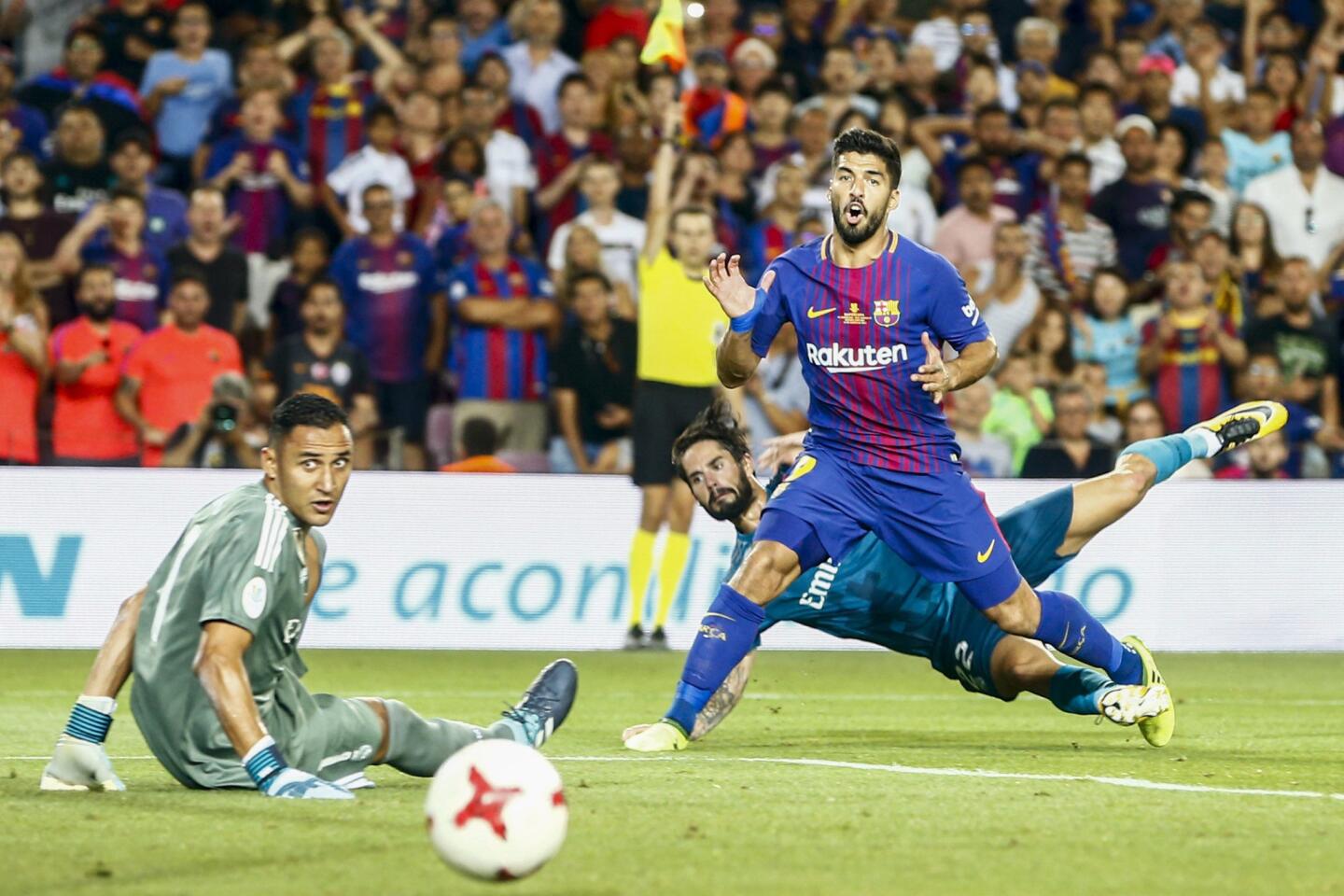 El delantero uruguayo del Barcelona Luis Suárez (d) dispara a puerta ante el portero costarricense del Real Madrid Keylor Navas (i). EFE
