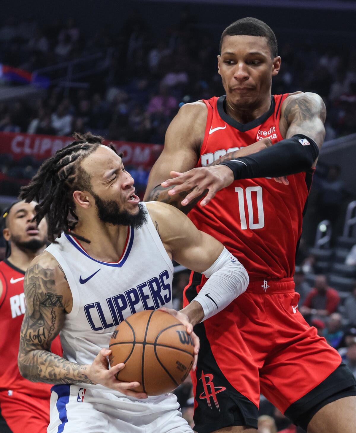 Clippers guard Amir Coffey, left, is fouled by Rockets forward Jabari Smith Jr. on a drive down the lane Sunday.