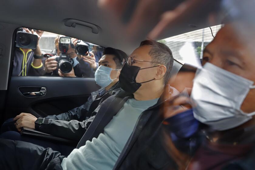 Former law professor Benny Tai, center, a key figure in Hong Kong's 2014 Occupy Central protests and also was one of the main organizers of the primaries, sits in a car after being arrested by police in Hong Kong, Wednesday, Jan. 6, 2021. About 50 Hong Kong pro-democracy figures were arrested by police on Wednesday under a national security law, following their involvement in an unofficial primary election last year held to increase their chances of controlling the legislature, according to local media reports. (AP Photo/Apple Daily)