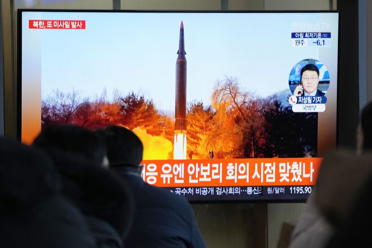 People watch a TV showing a file image of North Korea's missile launch during a news program at the Seoul Railway Station in Seoul, South Korea, Tuesday, Jan. 11, 2022. North Korea on Tuesday fired what appeared to be a ballistic missile into its eastern sea, its second weapons launch in a week, the militaries of South Korea and Japan said. The Korean letters read "UN Security Council meeting." (AP Photo/Ahn Young-joon)