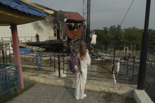 A student looks at a damaged higher education institution after a rocket hit the building in the Ukrainian capital Kyiv, Monday, Sept. 2 , 2024. On the first day of the school year in Ukraine, Russia launched a barrage of drones, cruise and ballistic missiles at Kyiv and possibly other cities, Ukraine's air force said early Monday. (AP Photo/Vasilisa Stepanenko)