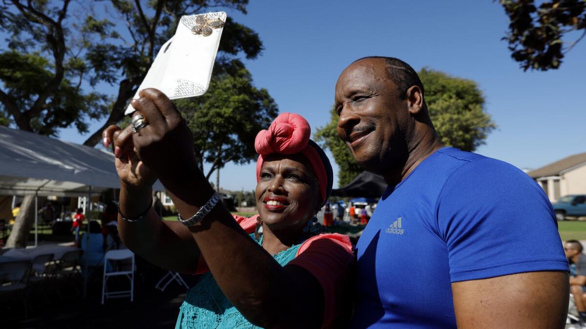 Butts takes a selfie with Toni Malone while attending a block club party in Inglewood.