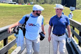 LACC director of golf Tom Gardner, right, walks across the bridge with Rory Sweeney, LACC's head pro and his caddie.