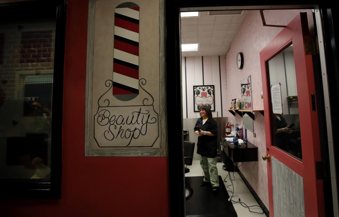 Inmate Alba Chavez stands in the beauty salon at the Century Regional Detention Facility, in Lynwood. The walls are painted in pink and gray stripes, and there is plenty of shampoo and hairspray to go around.