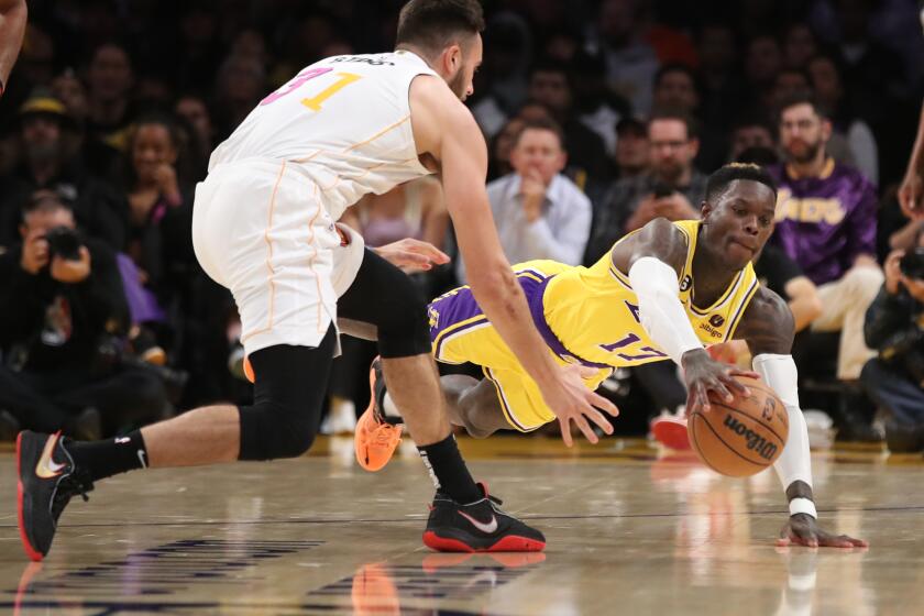 Los Angeles, CA - January 04: Lakers guard Dennis Schroder, right, battles Heat guard Max Strus for a loose ball in the first half at Crypto.Com Arena in Los Angeles Wednesday, Jan. 4, 2023. (Allen J. Schaben / Los Angeles Times)