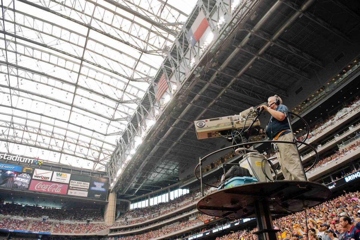 A CBS cameraman works during an NFL game in Houston in 2011. The upcoming start of the regular football season is believed to have pushed CBS and Time Warner Cable to settle their contract dispute.