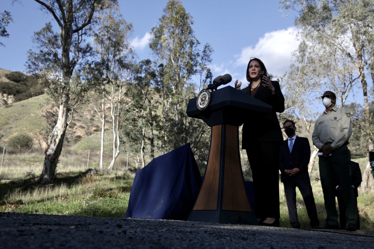 Vice President Kamala Harris stands at a podium outdoors.
