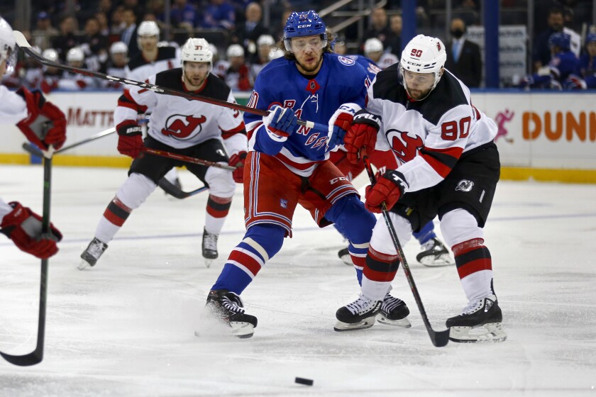 FILE — New York Rangers' Artemi Panarin and New Jersey Devils' Tomas Tatar battle for the puck during the first period of an NHL hockey game, Nov. 14, 2021, in New York. Figures released by New York gambling regulators, Feb. 4, 2022, show that New York has become the top market in the country for sports betting with $1.63 billion worth of wagers taken in the past four weeks. That surpassed the best month the previous leader, New Jersey, ever had by $300 million. (AP Photo/John Munson, File)