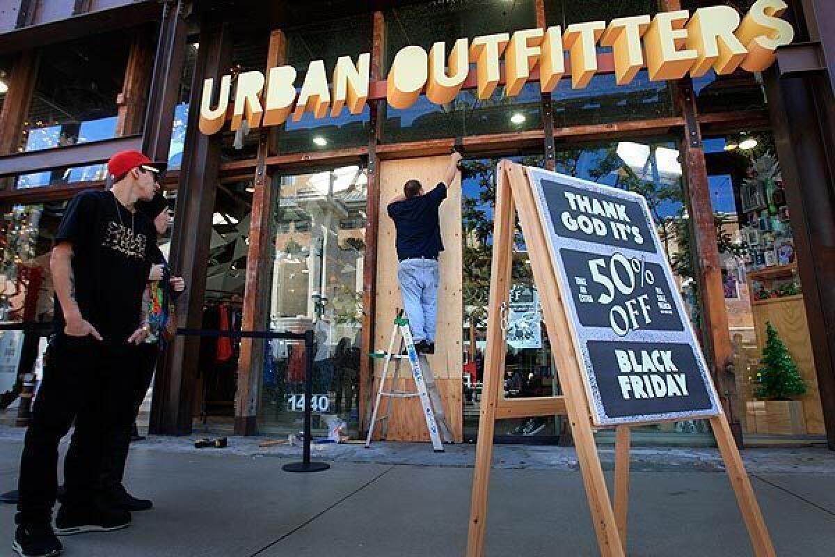 Mike Cruz replaces a glass door broken by Black Friday shoppers as they all tried to squeeze all at once into the Urban Outfitters store on Third Street Promenade. There were minor injuries reported at the scene in Santa Monica.