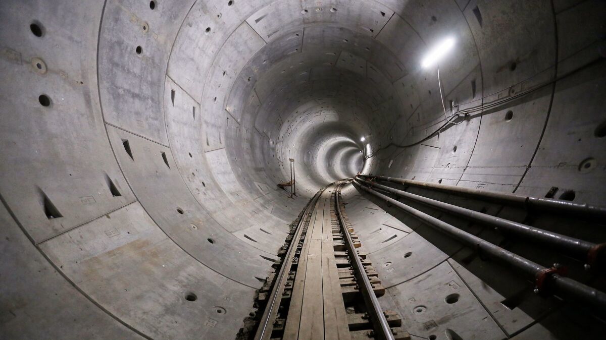 The first of two tunnels for the Regional Connector now stretches from Little Tokyo to the Financial District, but issues with aging utility lines have delayed the project's opening, Metropolitan Transportation Authority officials said Tuesday.