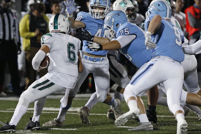 Oceanside quarterback Jakob Harris gets sacked by Corona del Mar's Dylan Wood (40) and Scott Gavin (75) in the CIF State Southern California Regional Division 1-A Bowl Game at Newport Harbor High on Saturday. PHOTO BY CHRISTINE COTTER/CONTRIBUTING PHOTOGRAPHER