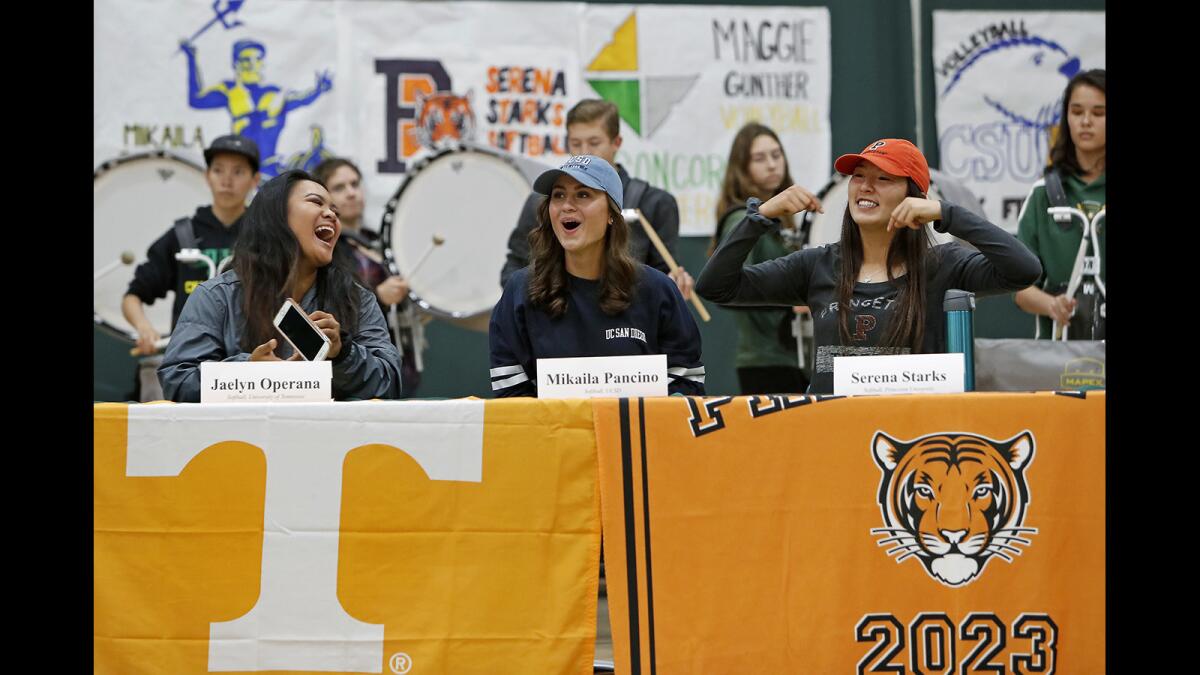 Softball players Jaelyn Operana, left, Mikalia Pancino and Serena Starks share a laugh during a signing day ceremony at Edison High in Huntington Beach on Thursday.