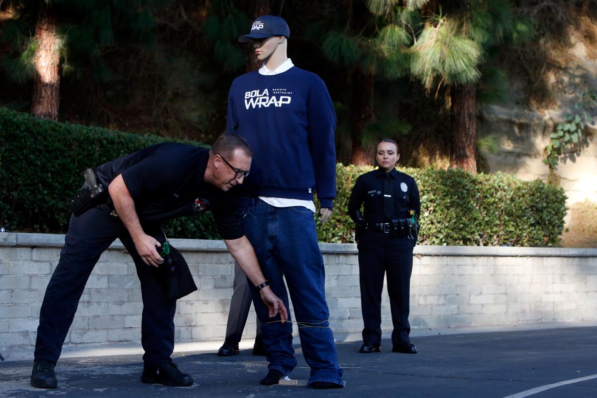 LOS ANGELES, CA-DECEMBER 9, 2019: Sargent Michael Hall demonstrates the tightness of a BolaWrap 100 device after it has been fired at the LAPD academy on December 9, 2019 in Los Angeles, California. The device fires a Kevlar cord to warp around a persons body. (Photo By Dania Maxwell / Los Angeles Times)