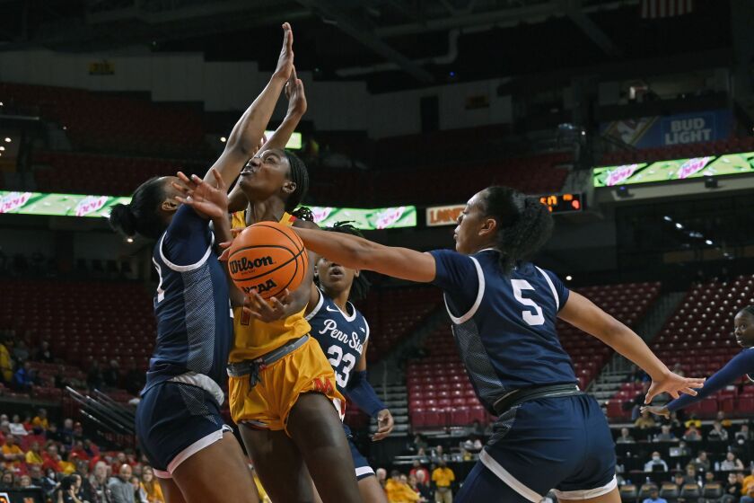 Penn State's Leilani Kapinus, right, blocks a shot by Maryland's Diamond Miller, center front, in the first quarter of an NCAA college basketball game in College Park, Md., Monday, Jan. 30, 2023. (Kenneth K. Lam/The Baltimore Sun via AP)