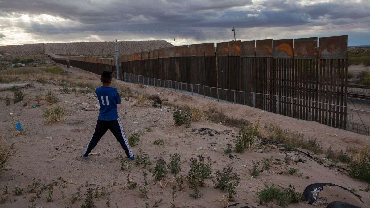 A boy in Ciudad Juarez, Mexico, looks at the area where a taller fence is being built along the U.S.-Mexico border near Sunland Park, N.M., on March 29.