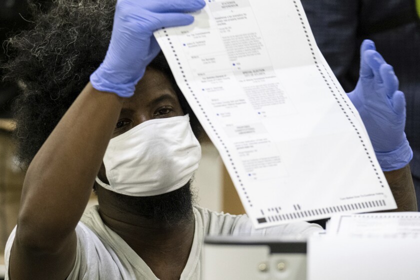 A man scans a ballot during the Fulton County presidential recount in Georgia on Nov. 25, 2020