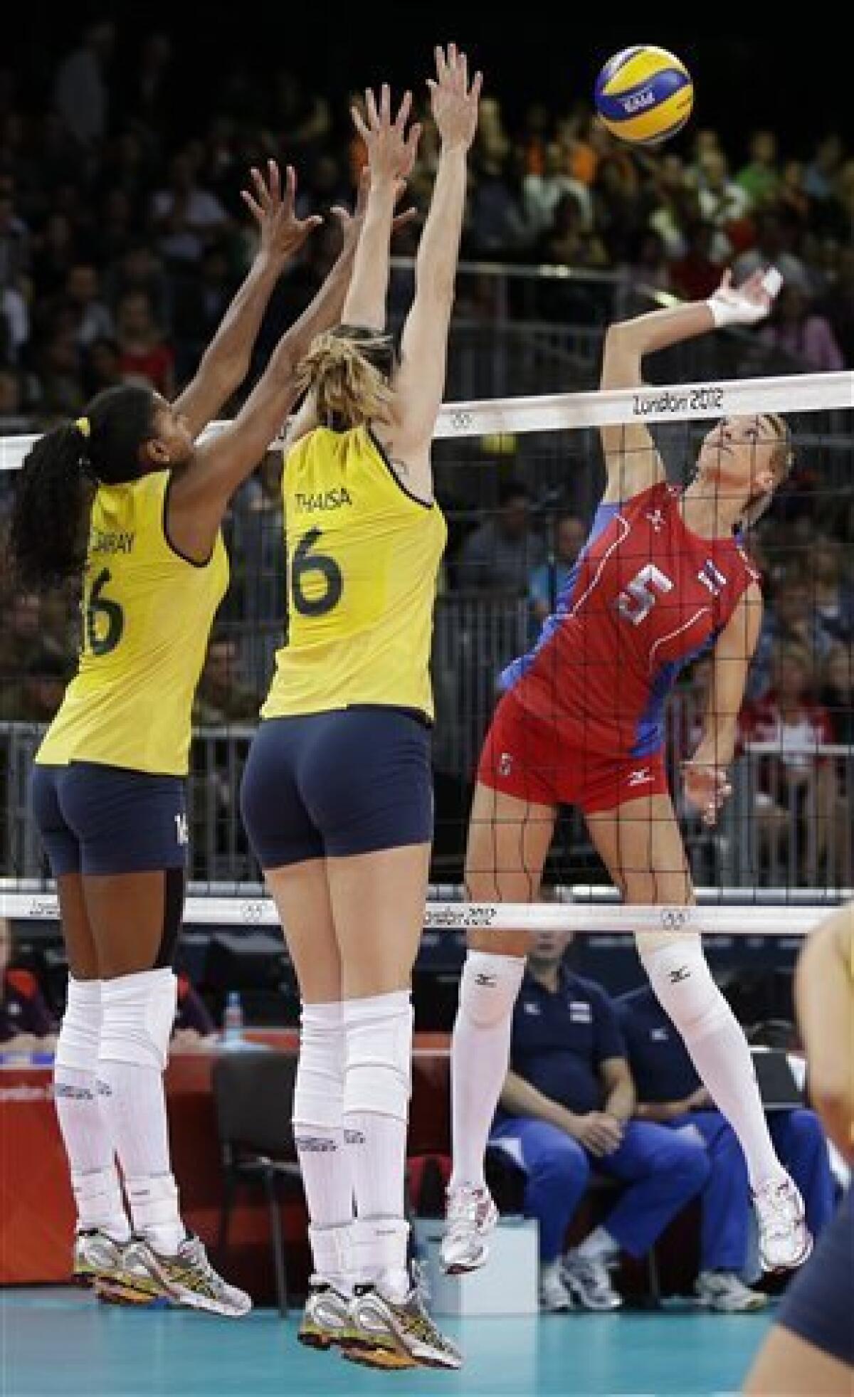 Russia's Liubova Shashkova (5) spikes the ball towards Brazil's Fernanda Rodrigues (16) and Thaisa Menezes (6) during a women's volleyball quarterfinal match at the 2012 Summer Olympics Tuesday, Aug. 7, 2012, in London. (AP Photo/Chris O'Meara)