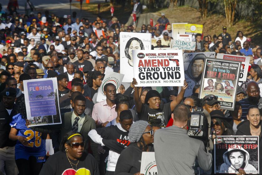 Hundreds of marchers waive their signs as they walk to the Florida Capitol Monday, March 10, 2014, for a rally in Tallahassee, Fla. Participants were rallying against the state's "Stand Your Ground" laws. (AP Photo/Phil Sears)