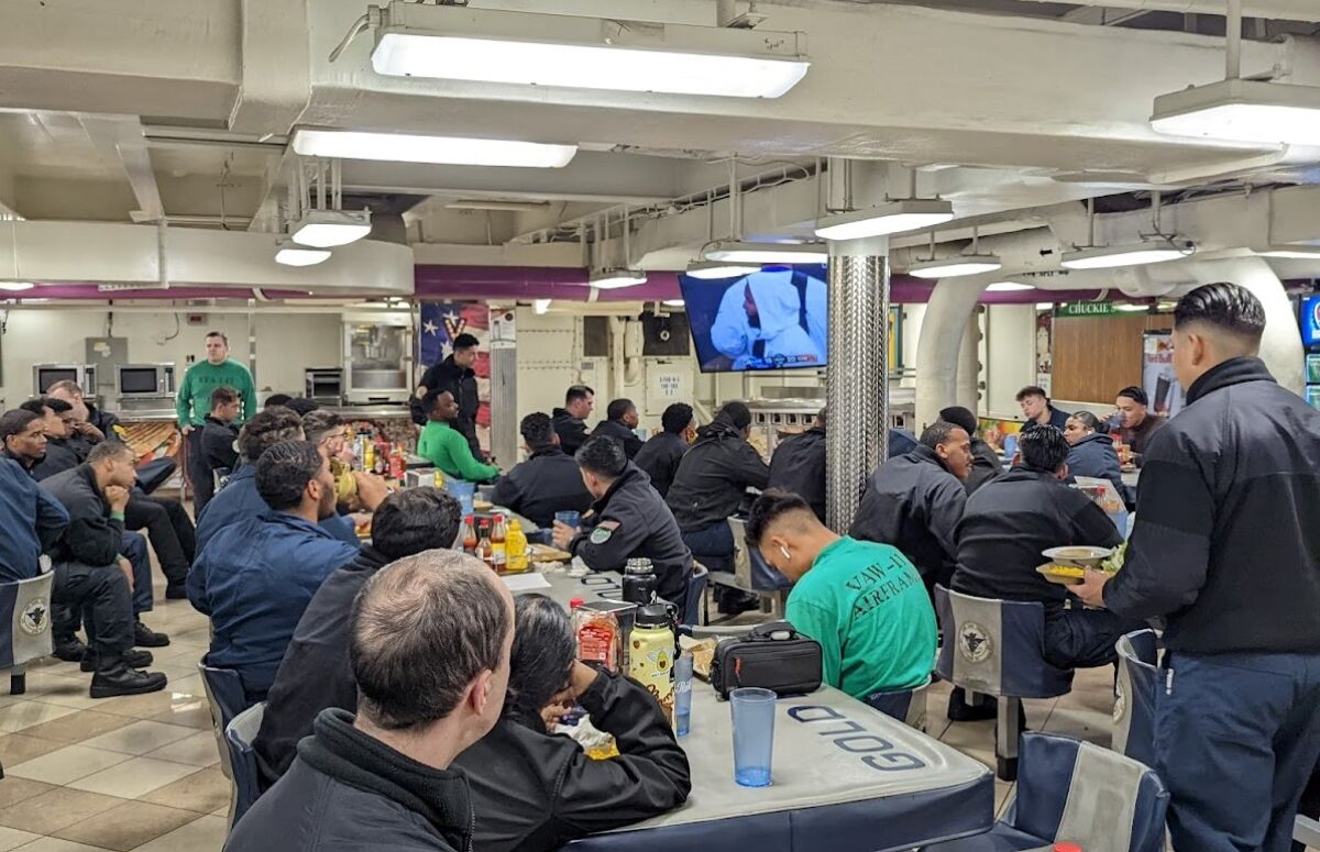 Sailors on the aircraft carrier Carl Vinson watch the Super Bowl on the mess decks of the ship