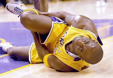 DOWN AND OUT: Kobe Bryant writhes on the court after suffering a severely sprained right ankle in the first quarter. He will have an MRI exam today.