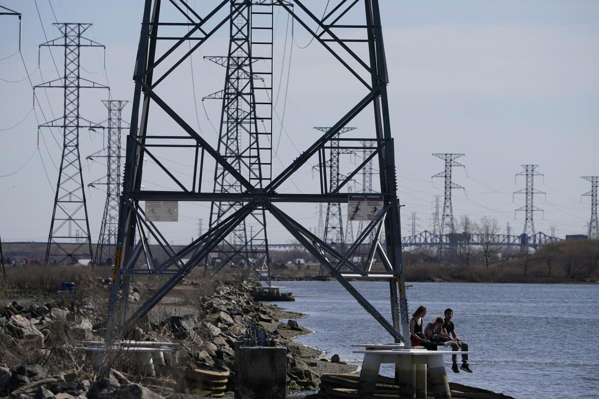 People sit at the base of a transmission tower