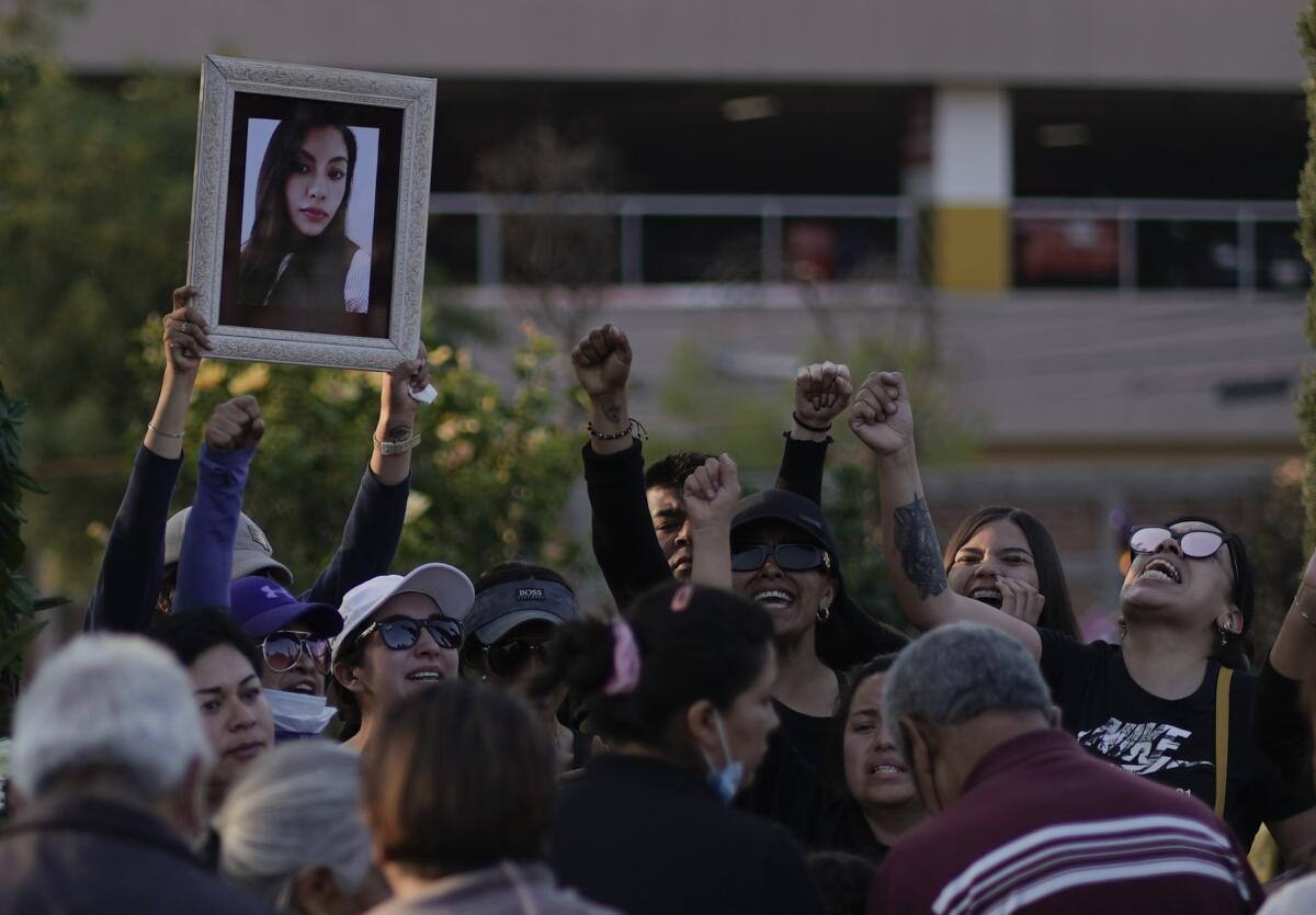 Friends of Monica Citlalli Diaz shout and raise their fists as they hold up her photo during her funeral.