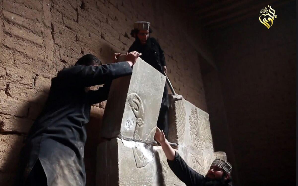This image taken from a video on April 11, 2015, is said to show members of Islamic State destroying a stone slab with a sledgehammer at the ancient Assyrian city of Nimrud in northern Iraq.