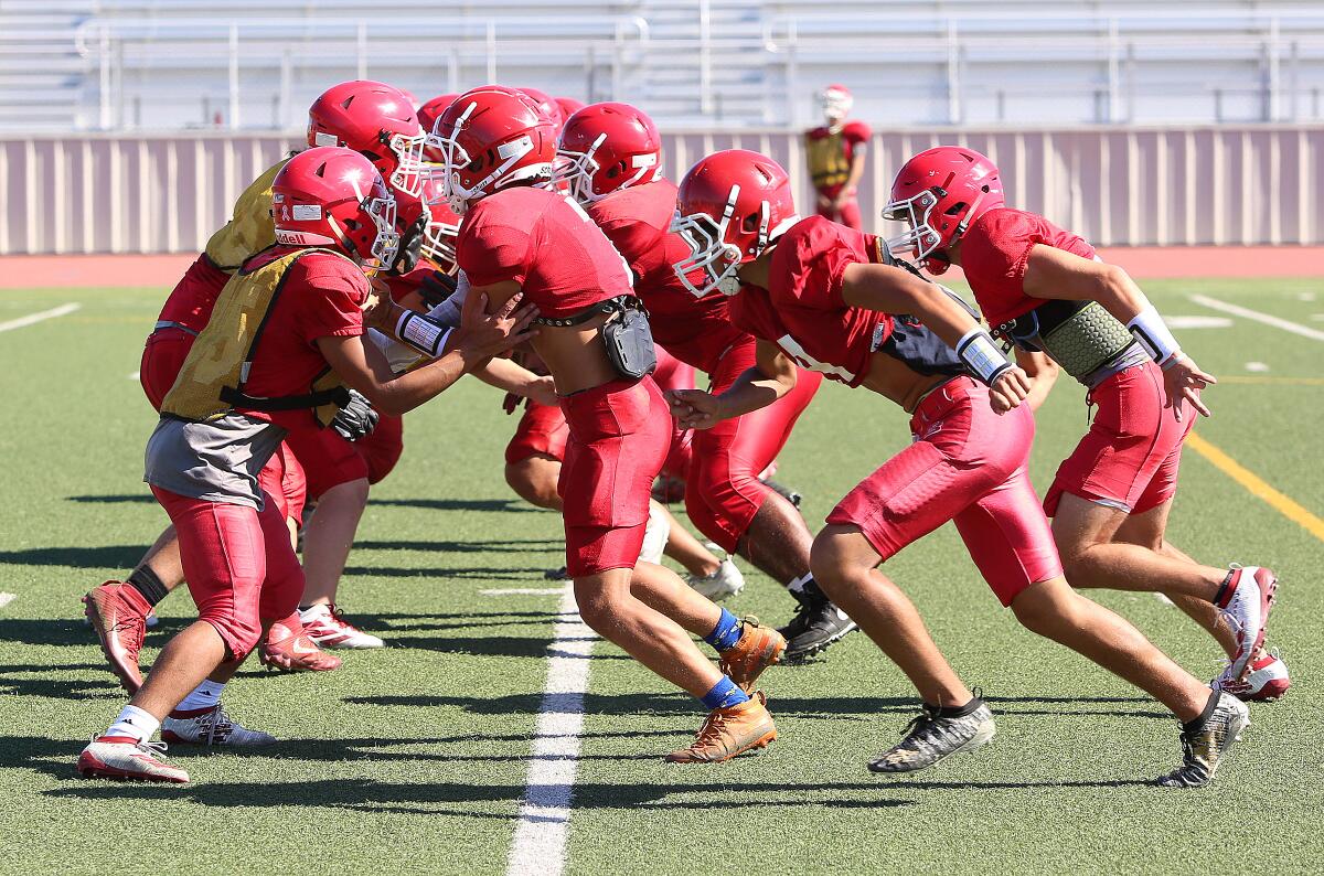 The Burroughs offensive and defensive lines collide while working on blocking assignments during a recent preseason practice at Memorial Field.