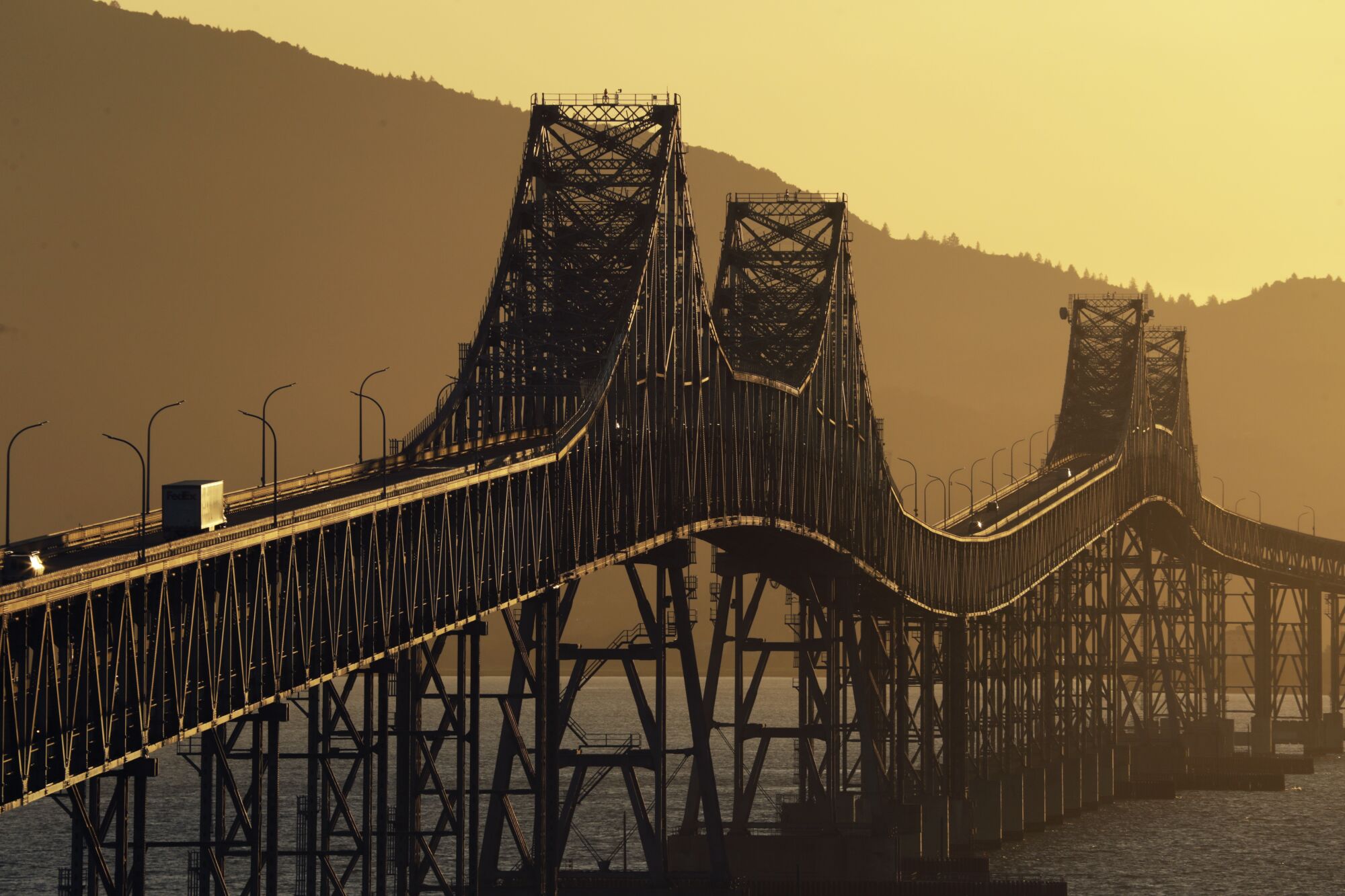 The Richmond-San Rafael Bridge against silhouetted hills and a canary yellow sky
