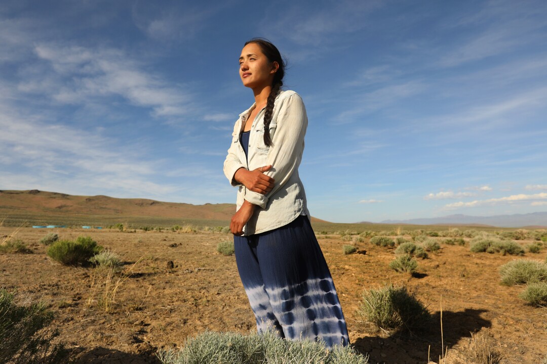 Daranda Hinkey stands near brush in Thacker Pass. 