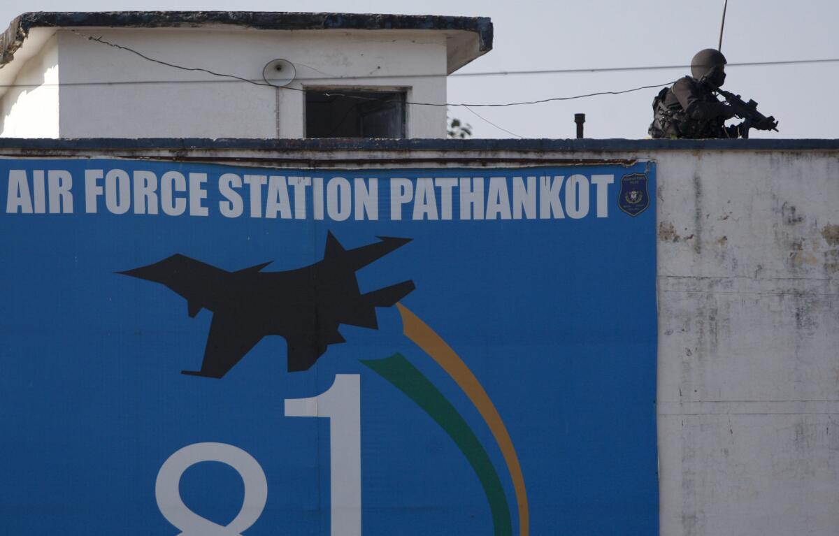 An Indian military commando is seen on the top of a building at the Indian air force base in Pathankot on Tuesday.