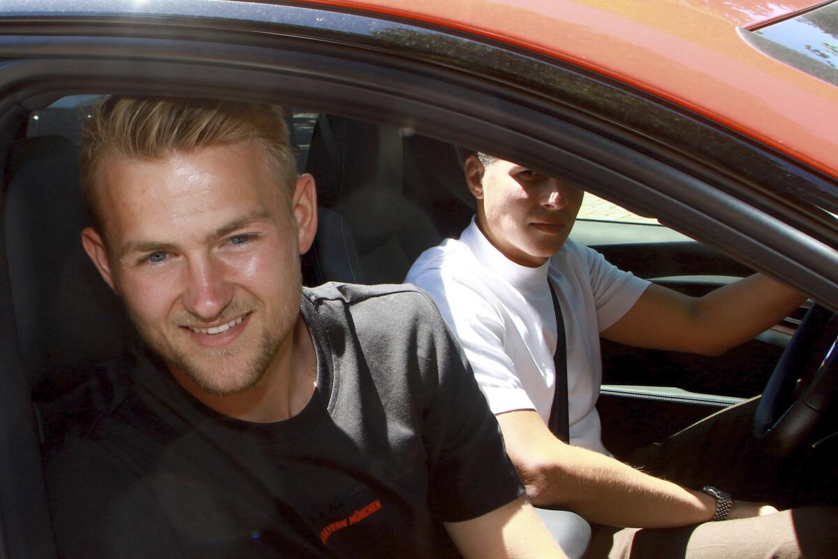 Matthijs de Ligt smiles from the window of a car as he leaves the offices of Bundesliga club FC Bayern Munich in Munich, Tuesday, July 19, 2022. (Mladen Lackovic/dpa via AP)