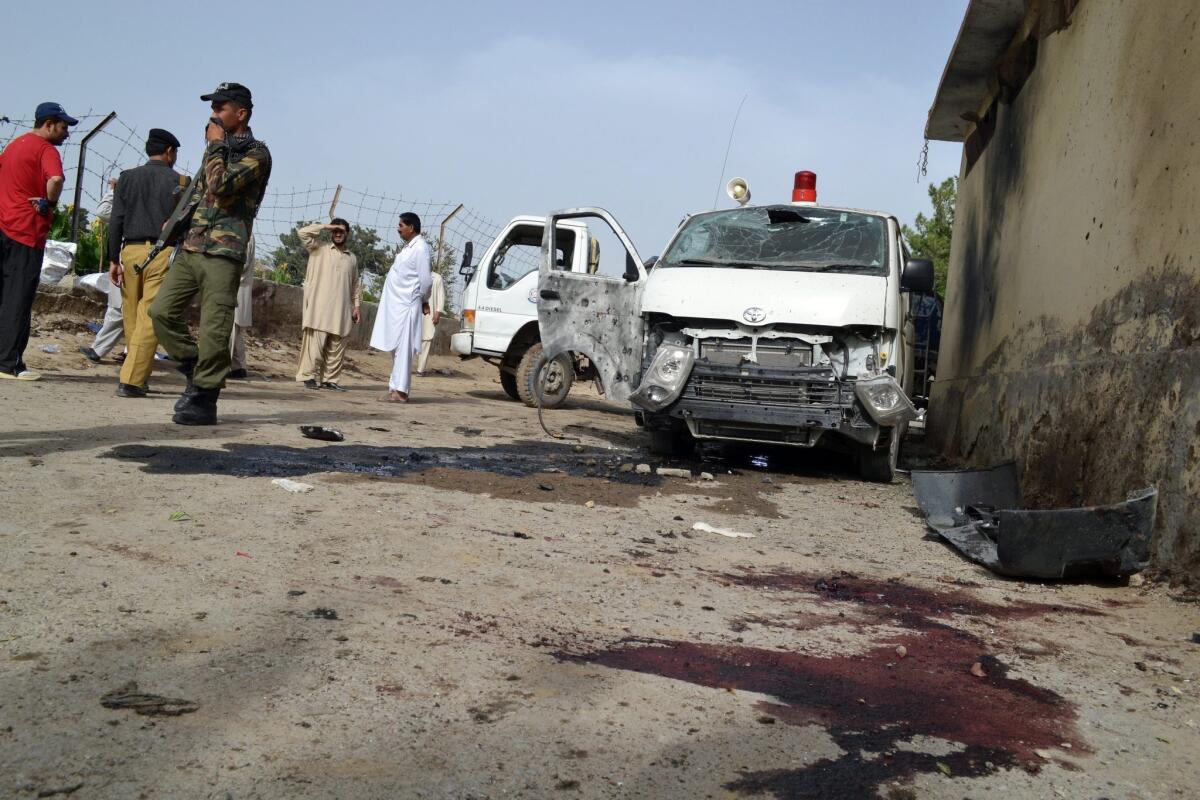 Pakistani security officials inspect the scene of a suicide bombing that targeted the funeral procession of a policeman in Quetta.