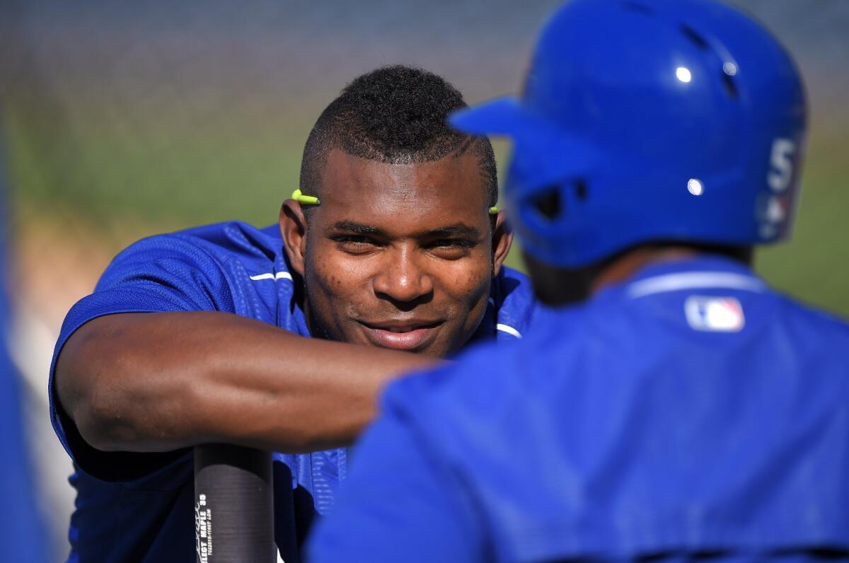 The Dodgers' Yasiel Puig, left, talks with Alberto Callaspo prior to a game against the San Francisco Giants on Friday.