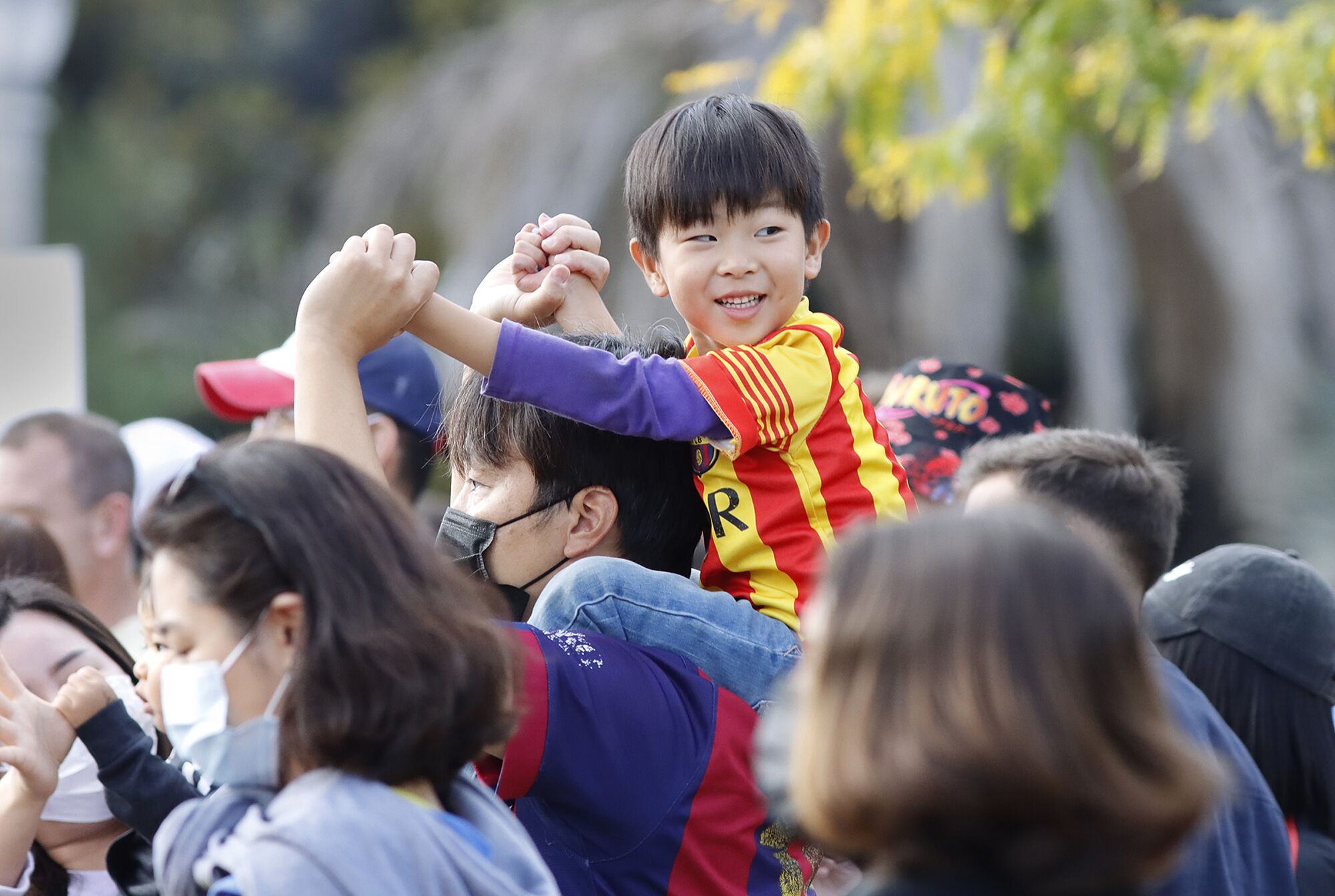 Skyler Yoo smiles while sitting atop his father Jayson Yoo's shoulders as they attended Korea Day.