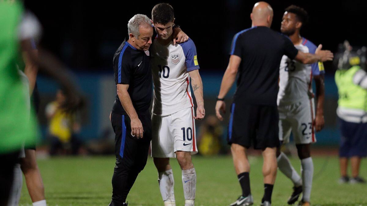 Christian Pulisic (10) and Kellyn Acosta (23) are comforted after the U.S. lost 2-1 to Trinidad and Tobago on Tuesday and did not qualify for the 2018 World Cup.