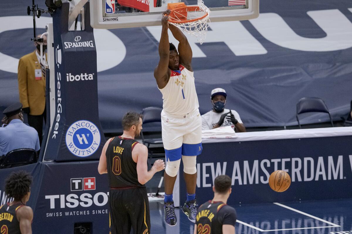New Orleans Pelicans forward Zion Williamson (1) dunks against Cleveland Cavaliers forward Kevin Love (0) during the first half of an NBA basketball game in New Orleans, Friday, March 12, 2021. (AP Photo/Matthew Hinton)