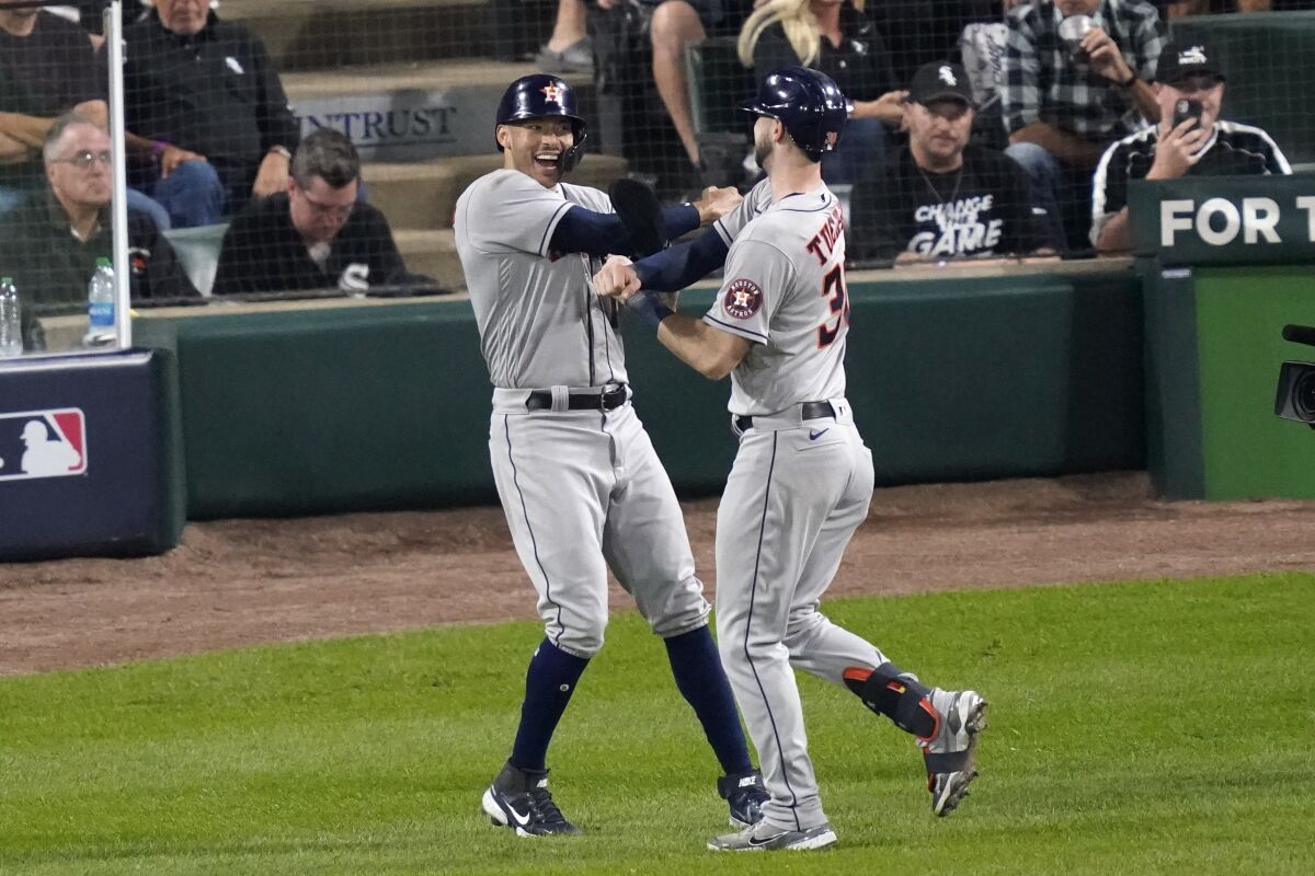 Houston Astros' Kyle Tucker, right, celebrates his two-run home run with Carlos Correa against the Chicago White Sox in the third inning during Game 3 of a baseball American League Division Series Sunday, Oct. 10, 2021, in Chicago. (AP Photo/Charles Rex Arbogast)