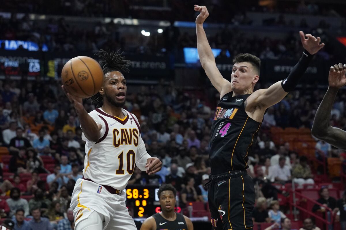 Cleveland Cavaliers guard Tim Frazier (10) passes the ball as Miami Heat guard Tyler Herro (14) defends during the first half of an NBA basketball game, Friday, March 11, 2022, in Miami. (AP Photo/Marta Lavandier)