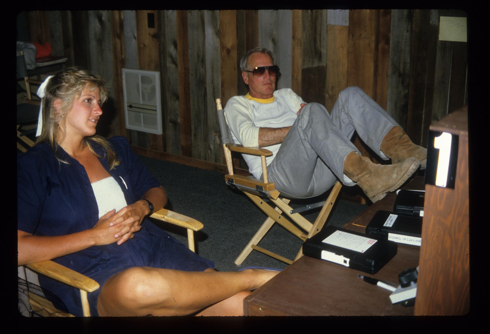 A woman, left, and a man relax in directors chairs