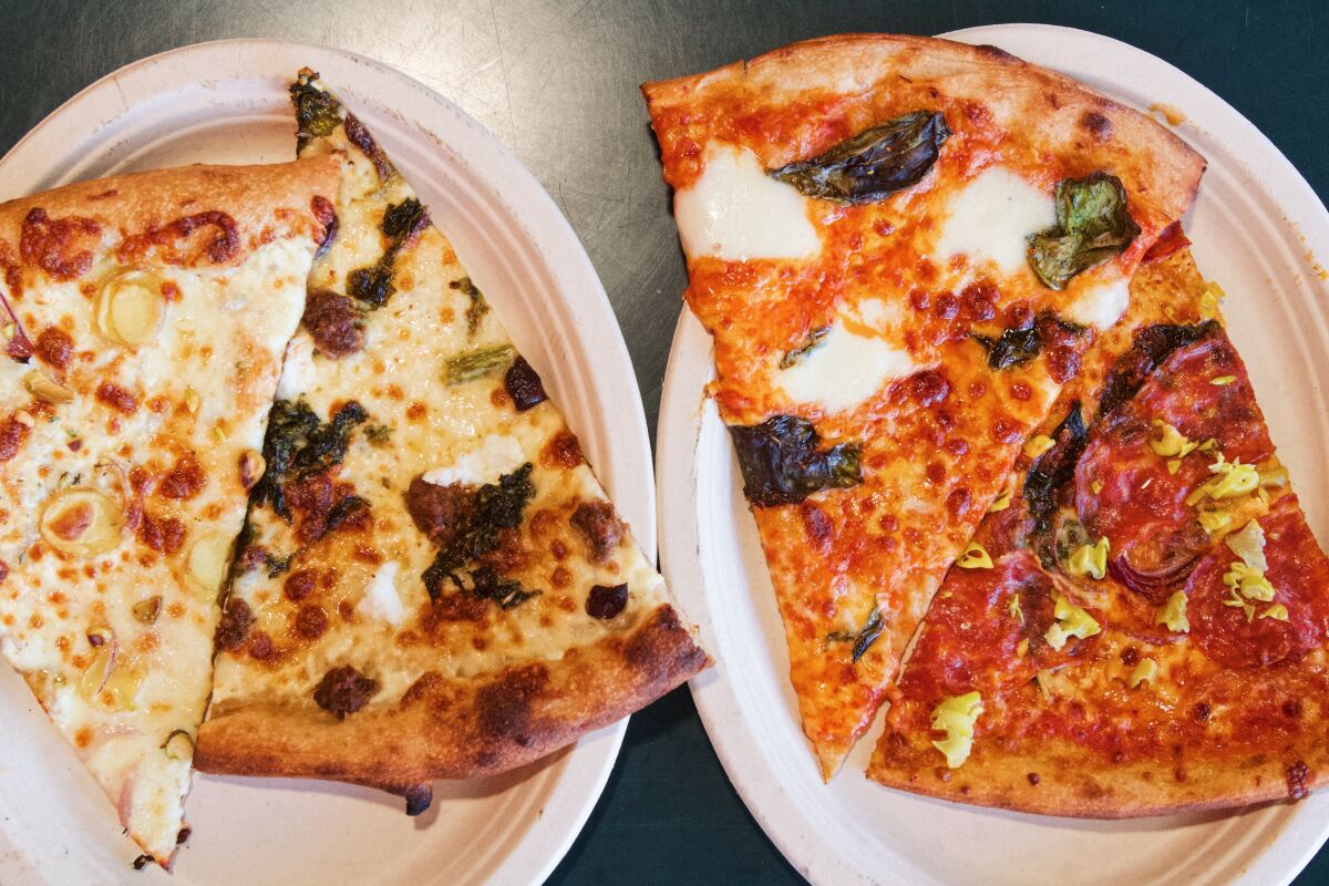 White slices and red slices of pizza served on paper plates at Friends & Family Pizza in the Original Farmers Market.