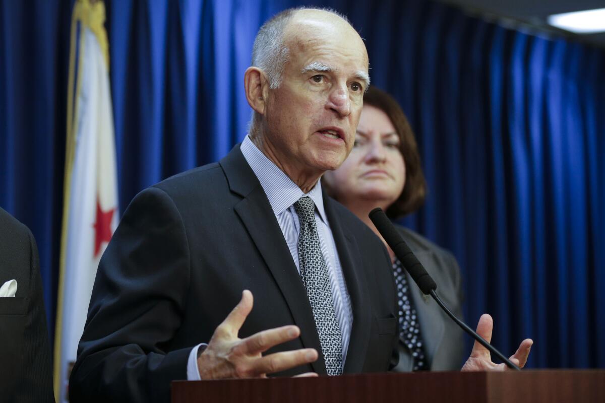 California Gov. Jerry Brown, with Assembly Speaker Toni Atkins (D-San Diego) in the background, talks in June about signing the state budget. Atkins was serving as acting governor on Wednesday.