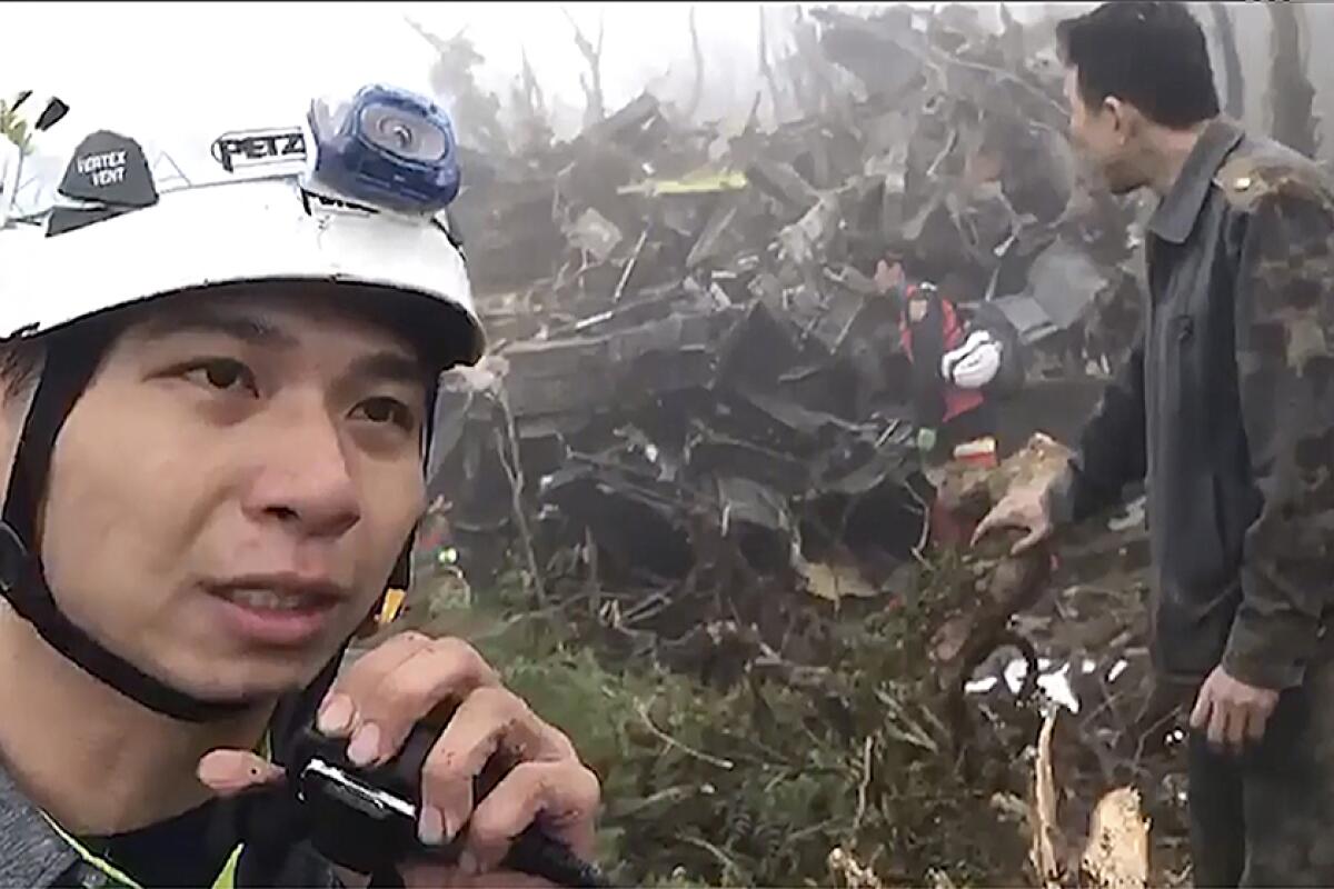 An image taken from video shows emergency crew members at the scene of a helicopter crash in northeastern Taiwan on Jan. 2, 2020.