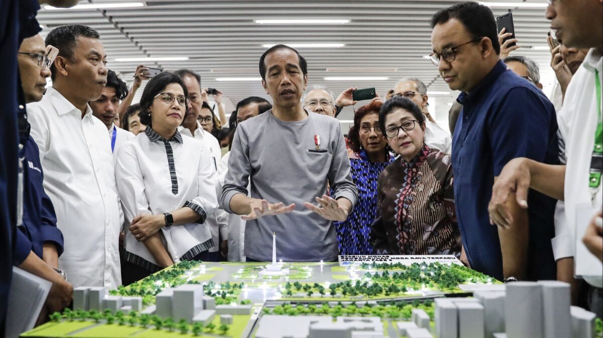 Indonesian President Joko Widodo, center, has made infrastructure building a priority of his administration. Here he is shown inspecting a model of Jakarta's new mass transit line in March 2019.