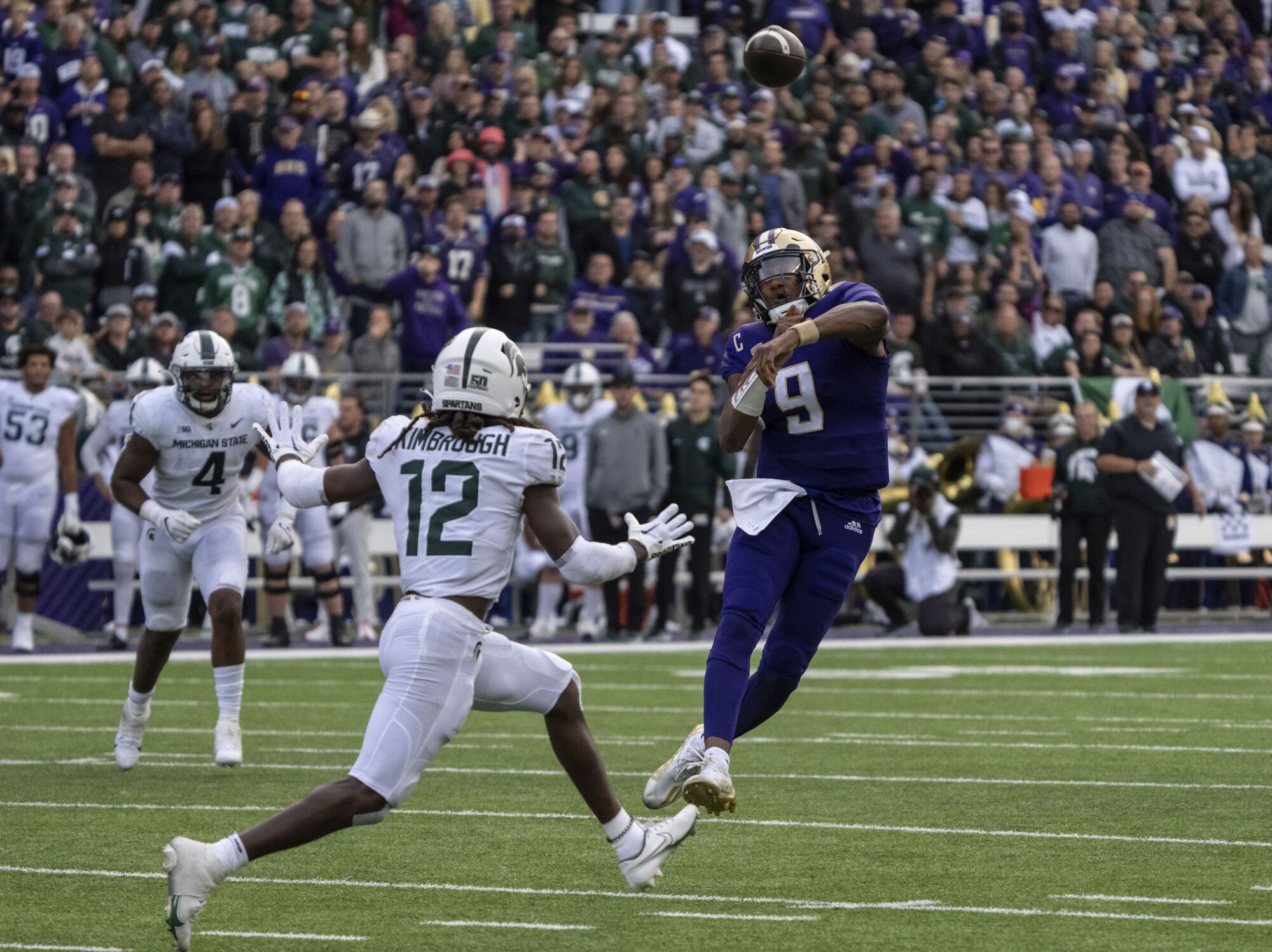 Washington quarterback Michael Penix Jr., right, throws a touchdown pass against Michigan State