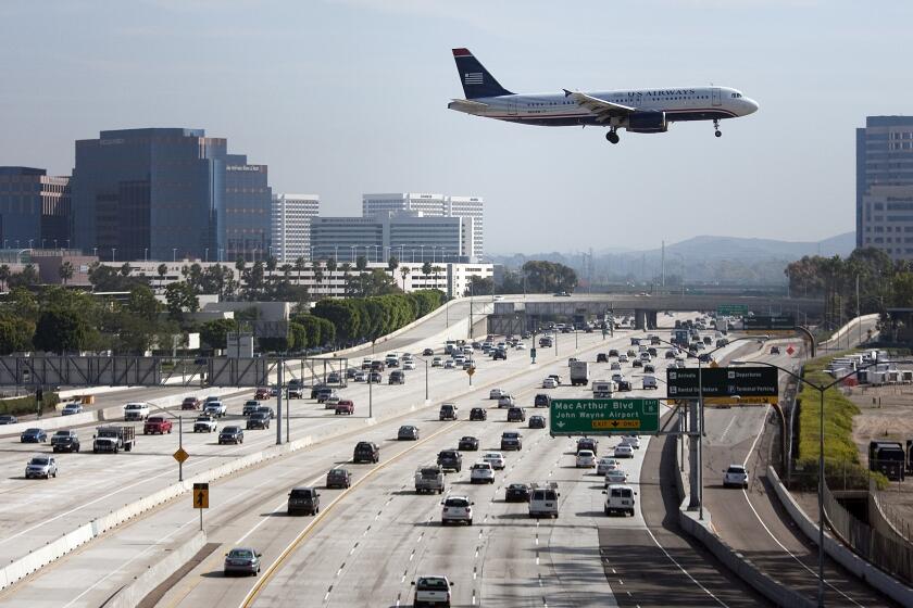Schaben, Allen J. –– B581716186Z.1 SANTA ANA, CA – NOVEMBER, 23, 2011: A U.S. Airways airplane flies over the 405 freeway as it approaches it's landing at John Wayne Airport in Orange County as travelers make their way to their destinations in time to celebrate Thanksgiving. ( Allen J. Schaben / Los Angeles Times)