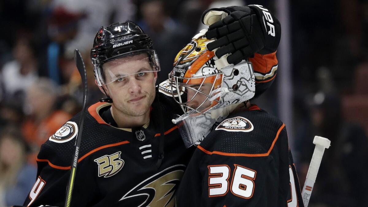 The Ducks' Cam Fowler, left, hugs teammate John Gibson after a win over the Colorado Avalanche.